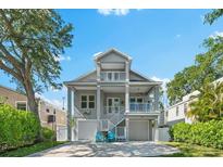 Charming two-story coastal home features dual garages and balconies, enhancing its curb appeal at 322 Ontario Ave, Crystal Beach, FL 34681