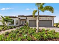Beautiful single-story home with stone accents, tile roof, three-car garage, and lush landscaping at 5958 Talon Preserve Dr, Nokomis, FL 34275