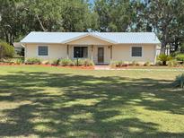 Charming single-story home featuring a well-maintained lawn and colorful landscaped flower beds at 1504 Swilley Rd, Plant City, FL 33567