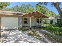 Charming home featuring a cozy front porch with rocking chairs and a well-maintained front yard at 186 Grand Ave, Brooksville, FL 34604