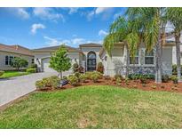 Charming home with a lush lawn, well-manicured landscaping, and a welcoming front entrance at 2165 Hollow Forest Ct, Wesley Chapel, FL 33543