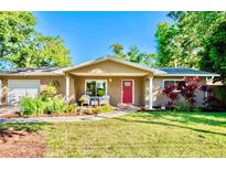 Charming single-story home with a well-manicured lawn, cozy front porch, and red front door at 2501 Crescent Dr, Largo, FL 33770