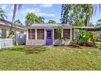Charming home featuring a well-manicured lawn and a lovely purple front door at 2909 60Th N Ave, St Petersburg, FL 33714
