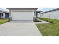 Exterior shot of a home's garage with a white garage door, concrete driveway, and landscaped front yard at 3590 Moscato Dr, Brooksville, FL 34602