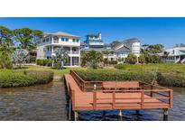 Stunning waterfront home featuring a private dock, lush landscaping, and architectural design at 404 Hillsborough St, Palm Harbor, FL 34683