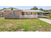 Charming single-Gathering home with a stone facade and a well-maintained front yard with white picket fence at 6556 S West Shore Cir, Tampa, FL 33616