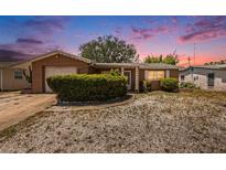 Cozy, single-story home with a well-maintained front yard and attached garage at 1051 Normandy Blvd, Holiday, FL 34691