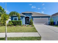 Charming single-story home featuring a well-manicured lawn and a two-car garage at 12123 Ledbury Commons Dr, Gibsonton, FL 33534