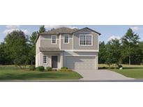 Charming two-story home with gray siding, a well-manicured lawn, and an attached two-car garage at 17504 Shirewood Way, Land O Lakes, FL 34638