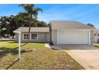 Charming single-story home with a well-maintained lawn and attached two-car garage at 1985 Hastings Dr, Clearwater, FL 33763