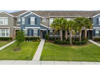 Charming townhouse featuring a manicured lawn, tasteful landscaping, and classic shutters, inviting curb appeal at 6337 Shore Vista Pl, Apollo Beach, FL 33572