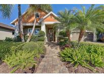 Beautiful home featuring mature landscaping, a brick paved walkway, and a welcoming front entrance at 7209 Meeting House Ln, Apollo Beach, FL 33572