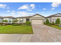 Charming single-story home with a well-manicured lawn, beautiful landscaping, and a brick paved driveway at 9921 Pier Point Ter, Parrish, FL 34219