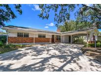 Charming single-story home featuring brick accents, a covered carport, and a well-maintained front yard at 10314 Lake Carroll Way, Tampa, FL 33618