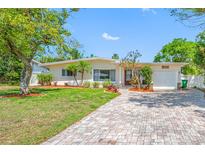 Charming single-story home with well-manicured lawn, landscaped flower beds, and paved driveway at 10821 101St Ave, Seminole, FL 33772