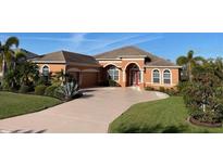 Charming, light orange single Gathering home featuring arched entry and well-manicured landscaping at 12619 50Th E Ct, Parrish, FL 34219