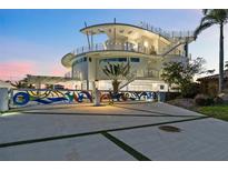Striking modern home featuring a unique architectural design, eye-catching colorful gate, and a spacious driveway at 12650 7Th E St, Treasure Island, FL 33706