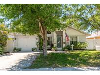 Charming single Gathering home with manicured lawn, flowering trees, and front-facing two car garage at 15856 49Th N St, Clearwater, FL 33762