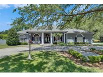 Charming home featuring stately columns, a well-manicured lawn, and beautiful landscaping at 1806 Chickasaw Trl, Valrico, FL 33596
