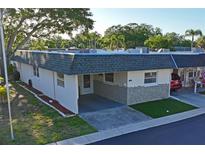 Charming one-story home with carport, stone accents, and well-maintained lawn at 200 Portree Dr, Dunedin, FL 34698