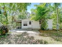 Charming single-story home with a screened porch and mature trees in a lush, green setting at 4041 Lane Rd, Zephyrhills, FL 33541
