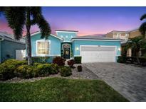 Charming, single-story home features lush landscaping, two-car garage, and a welcoming, light blue exterior at 424 Bahama Grande Blvd, Apollo Beach, FL 33572