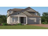 Charming two-story home with stone accents, grey siding, a well-kept lawn and three-car garage at 4807 Southern Valley Loop, Brooksville, FL 34601