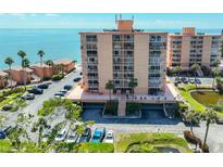 Stunning beachfront condo building with covered parking, palm trees, and direct ocean access at 7430 Sunshine Skyway S Ln # 403, St Petersburg, FL 33711
