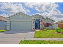 Charming one-story home featuring a two-car garage, well-maintained lawn, and colorful landscaping at 13131 Early Run Ln, Riverview, FL 33578