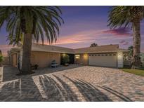 Beautiful single Gathering home with a large driveway and surrounded by mature palm trees at 15528 Allmand Dr, Hudson, FL 34667