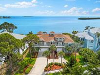 Beautiful waterfront home with lush landscaping, a private balcony, and a three-car garage at 2081 Pointe Alexis Dr, Tarpon Springs, FL 34689
