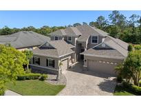 Beautiful two-story home showcasing a three-car garage and lush landscaping at 27318 Sora Blvd, Wesley Chapel, FL 33544