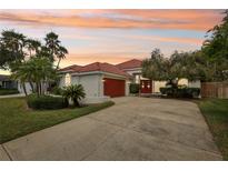 Beautiful single Gathering home with a red tile roof, red garage door, and well manicured yard at 915 Live Oak Ne Ter, St Petersburg, FL 33703