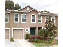 Inviting multi-story townhome with a one-car garage and manicured landscaping at 9508 Ashburn Creek Ln, Tampa, FL 33610