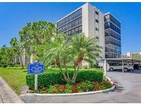 Exterior view of the condo building with palm trees and a manicured lawn in the foreground at 2700 Cove Cay Dr # 1-2D, Clearwater, FL 33760