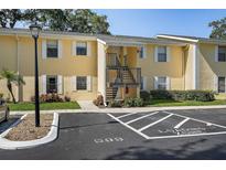 Two-story condo with a loading zone parking spot, stairs to the second floor, and light yellow paint at 3001 58Th S Ave # 509, St Petersburg, FL 33712