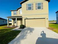 Inviting two-story home with a neutral exterior, neat landscaping, and a spacious driveway at 35003 Daisy Meadow Loop, Zephyrhills, FL 33541