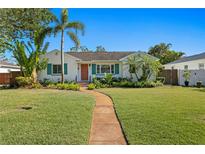 Charming home featuring a well-manicured lawn, mature palms, and a welcoming walkway to the front door at 432 39Th Ne Ave, St Petersburg, FL 33703