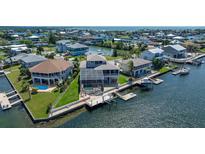Waterfront home featuring a screened pool, boat dock, and lush landscaping at 4363 Biscayne Dr, Hernando Beach, FL 34607