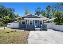 Charming single-story home with a quaint front porch, blue door, and a well-manicured front yard at 6939 3Rd N St, St Petersburg, FL 33702
