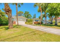 Charming single-story home with a well-manicured lawn and mature palm trees at 775 S Bayshore Blvd, Safety Harbor, FL 34695