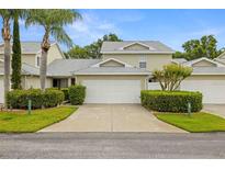 Charming home with a two-car garage, well-maintained landscaping, and mature palm trees in a residential neighborhood at 1640 Lullwater Ln, Lutz, FL 33549