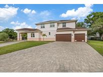 Elegant two-story home featuring a three-car garage and a spacious brick driveway at 1915 Belleair Rd, Clearwater, FL 33764