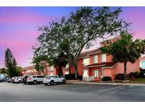Condo exterior at dusk with parking, colorful buildings, and mature trees at 3675 41St S Way # K, St Petersburg, FL 33711