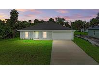 Charming single-story home featuring a well-manicured lawn and an attached two-car garage at 3879 E Price Blvd, North Port, FL 34288