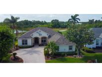Beautiful single-story home showcasing manicured landscaping, elegant architecture, and a serene pond view at 522 Planters Manor Way, Bradenton, FL 34212