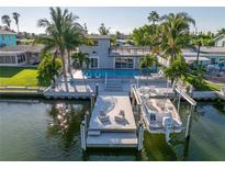 Stunning waterfront home featuring a private boat dock, boat lift, pool, and outdoor entertaining spaces at 533 Lillian Dr, Madeira Beach, FL 33708