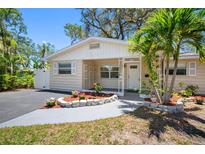 Charming single-story home with a well-maintained front yard, vibrant flowers and a cozy, covered entryway at 568 La Plaza S Ave, St Petersburg, FL 33707