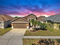 Charming single-story home with landscaped front yard and attached two-car garage at 8603 Sandy Plains Dr, Riverview, FL 33578