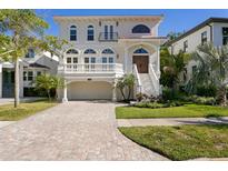 Stunning two-story home with a brick driveway, manicured lawn, and grand staircase entry at 102 Adriatic Ave, Tampa, FL 33606